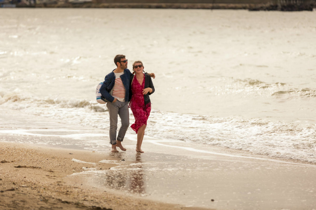 情侣在滨海特鲁维尔的海滩上漫步